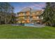 A spacious backyard with a pool, dining table, grill, lush green lawn, and multi-level balconies, ideal for outdoor living at 614 Norton St, Longboat Key, FL 34228