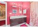 Bathroom featuring double sinks, cabinet storage, decorative shower curtain, and accent lighting at 614 Norton St, Longboat Key, FL 34228