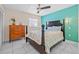 Bedroom with a teal accent wall, ceiling fan, white tile floors, and a dark wood bed and dresser at 614 Norton St, Longboat Key, FL 34228