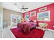 Bright bedroom with red accent wall, ceiling fan, and access to a private balcony at 614 Norton St, Longboat Key, FL 34228