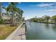 Canal view from the dock, with a concrete walkway and wooden deck leading to the water, surrounded by lush greenery at 614 Norton St, Longboat Key, FL 34228