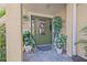 Inviting front door featuring a wreath, sidelights, and complemented by potted plants at 614 Norton St, Longboat Key, FL 34228