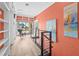 Bright hallway with a wall of built-in bookshelves, modern railings, and a balcony overlooking the beach at 614 Norton St, Longboat Key, FL 34228
