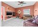 Comfortable living room with a TV, workout bike, and plush seating on white tile floors at 614 Norton St, Longboat Key, FL 34228