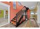 Stylish staircase featuring wood treads, an orange accent wall with artwork, and wood-look flooring at 614 Norton St, Longboat Key, FL 34228
