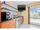 Wet bar with wine fridge, granite counters, and balcony access at 614 Norton St, Longboat Key, FL 34228