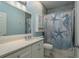 Charming bathroom with blue accents, vanity, and shower-tub combination with nautical themed shower curtain at 632 S Florida Ave, Tarpon Springs, FL 34689