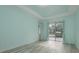 Light blue bedroom featuring sliding glass doors leading to pool area and light gray wood-look flooring at 632 S Florida Ave, Tarpon Springs, FL 34689
