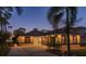 Beautiful home exterior with lush palm trees and a well-manicured lawn at dusk at 632 S Florida Ave, Tarpon Springs, FL 34689