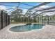 Beautiful kidney-shaped pool inside a screened enclosure with brick pavers at 632 S Florida Ave, Tarpon Springs, FL 34689