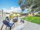 Backyard features a fire pit area with chairs, grassy lawn, and screened-in patio at 6521 Cedarbrook S Dr, Pinellas Park, FL 33782