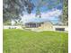 Large backyard with green grass, screened patio, and fenced perimeter at 6521 Cedarbrook S Dr, Pinellas Park, FL 33782