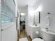 Bright bathroom with white vanity, toilet, mirror and wood-look flooring at 6521 Cedarbrook S Dr, Pinellas Park, FL 33782