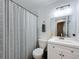This bathroom offers a large mirror, sink and a shower with curtain at 6521 Cedarbrook S Dr, Pinellas Park, FL 33782