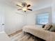 This bedroom features modern decor, a ceiling fan, and a bright window at 6521 Cedarbrook S Dr, Pinellas Park, FL 33782