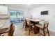 Bright dining area with wood floors and view to screened-in lanai with furniture at 6521 Cedarbrook S Dr, Pinellas Park, FL 33782