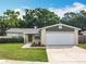 Charming single-story home with a well-manicured lawn, mature trees, and a two-car garage at 6521 Cedarbrook S Dr, Pinellas Park, FL 33782