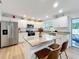 Well-lit kitchen with white cabinets, stainless steel appliances, and a granite island at 6521 Cedarbrook S Dr, Pinellas Park, FL 33782