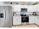 This upgraded kitchen features stainless steel appliances, granite countertops, and bright white cabinetry at 6521 Cedarbrook S Dr, Pinellas Park, FL 33782