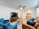 Cozy living room featuring wood floors, comfortable seating, and a ceiling fan at 6521 Cedarbrook S Dr, Pinellas Park, FL 33782