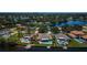 An aerial view captures three waterfront homes each boasting its own private pool, lush landscaping, and boat dock on the canal at 671 Tallahassee Ne Dr, St Petersburg, FL 33702