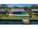 Aerial view of waterfront home with pool, lanai, dock and fenced yard at 671 Tallahassee Ne Dr, St Petersburg, FL 33702