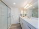 Bathroom with a walk-in shower, white cabinets, marble countertop, and modern fixtures at 671 Tallahassee Ne Dr, St Petersburg, FL 33702