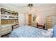 Bright bedroom with a built-in desk, shelving, and a blue and white patterned bedspread at 671 Tallahassee Ne Dr, St Petersburg, FL 33702