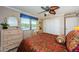 Bedroom with a decorative ceiling fan, large windows overlooking the water, and a dresser at 671 Tallahassee Ne Dr, St Petersburg, FL 33702