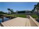 Dock overlooks grassy yard and waterfront home with screened in porch at 671 Tallahassee Ne Dr, St Petersburg, FL 33702