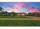 Well-maintained home with lush lawn, palm trees, and brick driveway at 671 Tallahassee Ne Dr, St Petersburg, FL 33702