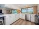Bright kitchen with white cabinetry, stainless steel appliances, and scenic water views, creating a delightful cooking space at 671 Tallahassee Ne Dr, St Petersburg, FL 33702