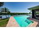 Backyard showcasing a sparkling pool with brick trim and waterfront views, ideal for relaxation and entertaining at 671 Tallahassee Ne Dr, St Petersburg, FL 33702