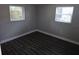 Bedroom showcasing two windows and dark flooring at 6731 Old Main St, New Port Richey, FL 34653