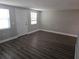 Bright living room with wood floors, white trim, a front door and two windows at 6731 Old Main St, New Port Richey, FL 34653