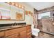 Well-lit bathroom with a large mirror, stone-look tile, and a shower at 700 Bowsprit Pl, Palm Harbor, FL 34685