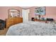 Bright bedroom with a floral bedspread, light wood dresser, and soft pink walls at 700 Bowsprit Pl, Palm Harbor, FL 34685