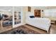 Bedroom with hardwood floors, white bedding, and open doorway to living area at 700 Bowsprit Pl, Palm Harbor, FL 34685