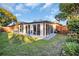 Enclosed sunroom with sliding glass doors, overlooking a well-maintained backyard and garden at 700 Bowsprit Pl, Palm Harbor, FL 34685