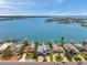 Stunning aerial view of waterfront homes with docks and boat lifts on a sunny day with blue skies at 7115 Bay St, St Pete Beach, FL 33706