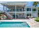 Amazing backyard with a refreshing pool, covered patio, and stairs leading to an upper deck at 7115 Bay St, St Pete Beach, FL 33706