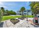 Expansive backyard featuring lush landscaping, raised garden beds, pool and water views offering an outdoor oasis at 7115 Bay St, St Pete Beach, FL 33706