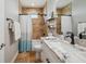 Bathroom featuring vanity with white cabinets, granite countertop, and decorative tile shower at 7115 Bay St, St Pete Beach, FL 33706