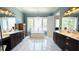 Bright bathroom features dual vanities, marble floors, standalone tub, chandelier, and window with water view at 7115 Bay St, St Pete Beach, FL 33706