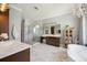 Spacious bathroom featuring marble floors, glass shower, dual sink vanity and a modern standalone bathtub at 7115 Bay St, St Pete Beach, FL 33706