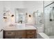 Bright bathroom features a marble countertop, vessel sink, Edison bulb lighting and a glass enclosed shower at 7115 Bay St, St Pete Beach, FL 33706