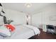 Bright bedroom featuring a bed with white bedding, a closet, a desk and dark wood floors at 7115 Bay St, St Pete Beach, FL 33706