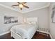 Comfortable bedroom with dark wood floors, neutral bedding, and a ceiling fan at 7115 Bay St, St Pete Beach, FL 33706