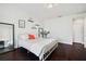 Bright bedroom with a white bed frame, dark wood floors, and neutral decor at 7115 Bay St, St Pete Beach, FL 33706