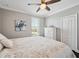 Bright bedroom with a window, white dresser, light walls, and neutral bedding at 7115 Bay St, St Pete Beach, FL 33706